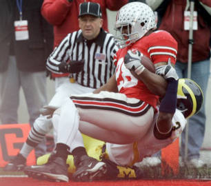 Ohio State running back Chris Wells (28) makes a touchdown run as Michigan safety Stevie Brown (3) tackles in the end zone during the first quarter of an NCAA college football game Saturday, Nov. 22, 2008 in Columbus, Ohio. (AP Photo/Kiichiro Sato)