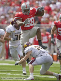 Buckeyes running back Beanie Wells hurdles Minnesota safety Kyle Theret en route to a 21-yard gain during the second quarter Saturday in Columbus.  (The Ozone)