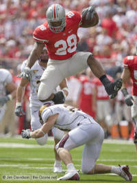 Buckeyes running back Beanie Wells hurdles Minnesota safety Kyle Theret en route to a 21-yard gain during the second quarter Saturday in Columbus.  (The Ozone)