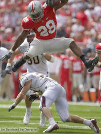 Buckeyes running back Beanie Wells hurdles Minnesota safety Kyle Theret en route to a 21-yard gain during the second quarter Saturday in Columbus.  (The Ozone)