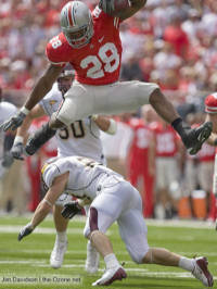 Buckeyes running back Beanie Wells hurdles Minnesota safety Kyle Theret en route to a 21-yard gain during the second quarter Saturday in Columbus.  (The Ozone)