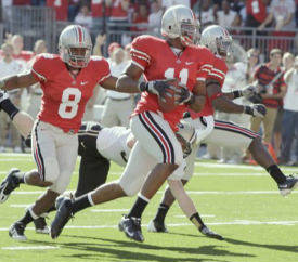 After picking up a blocked punt by teammate Malcolm Jenkins, far right, Ohio State's Etienne Sabino (11) runs the ball in for a touchdown against Purdue in first quarter NCAA college football action in Columbus, Ohio on Saturday, Oct. 11, 2008. Trailing Sabino is OSU's Aaron Gant (8) and Purdue's Joe Holland. (AP Photo/Amy Sancetta)